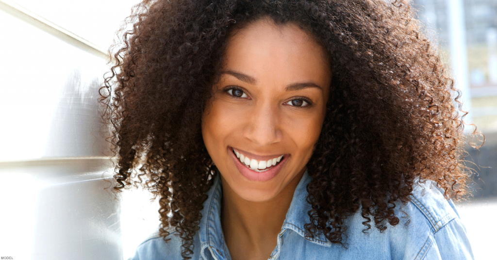 Smiling woman proudly displaying flawless skin