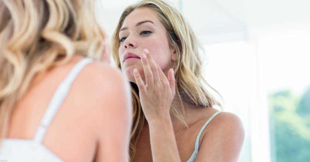 Woman examining the texture of her skin