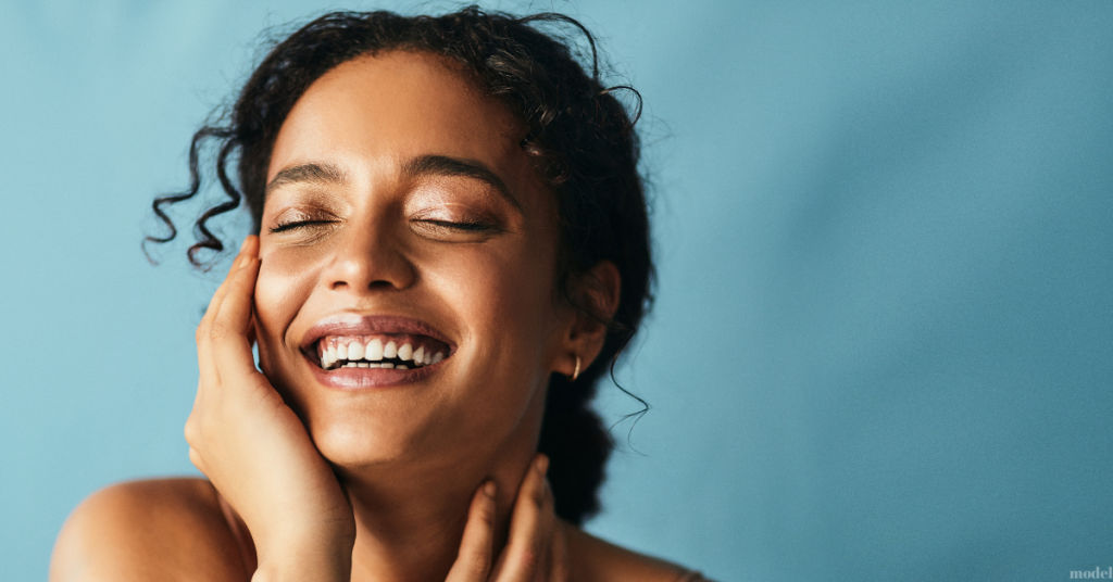 young woman touching her cheek and neck (model)