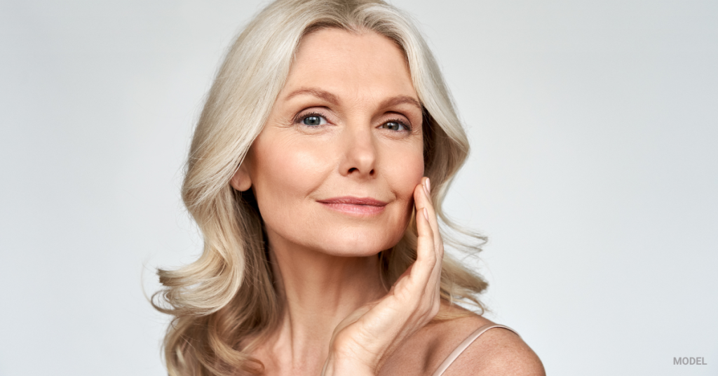 Mature woman admiring her beautiful flawless skin (MODEL)