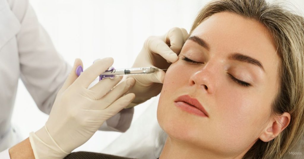 A woman getting an injection from a healthcare professional. (Models)